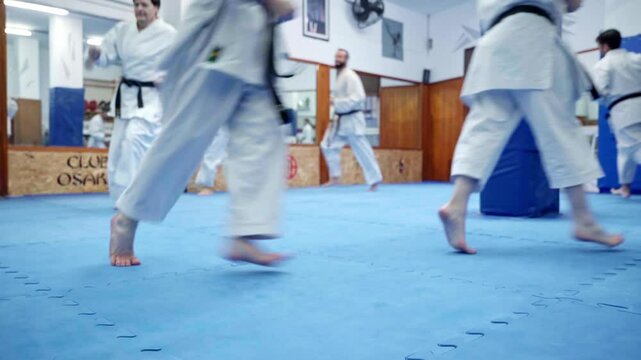 Karate athletes running during training in dojo