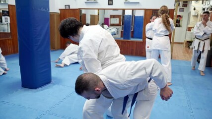 Karate athletes practicing self defense techniques in dojo - Powered by Adobe