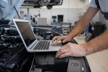 Mechanic using laptop for diagnostics