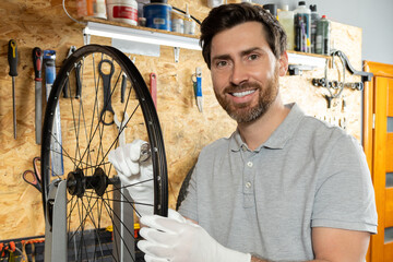 Mechanic in white gloves lifting wheel