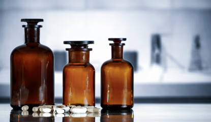 Medicine Bottles on Table – Doctor’s Office in Background. Medical consultation room and...