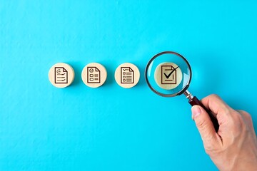 Magnifying Glass Highlighting Completed Task Icon on Wooden Block – Concept of Quality Control, Task Prioritization, Project Management, and Performance Review