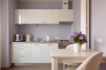 A small, modern kitchen with lilac flowers.