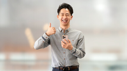 スマートフォンを持っていいね！のポーズをする男性