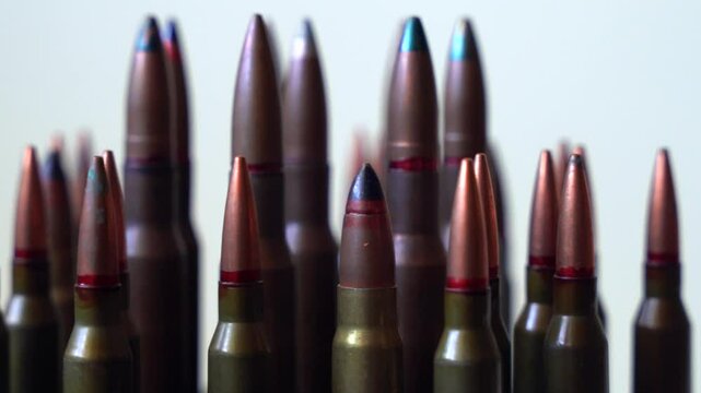 Different types of different types of bullets close-up rotating on white background, shallow depth of field
