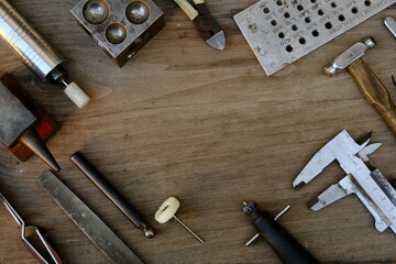 Jeweler's workplace. Top view of jeweler's workbenche with different tools on a wooden table....