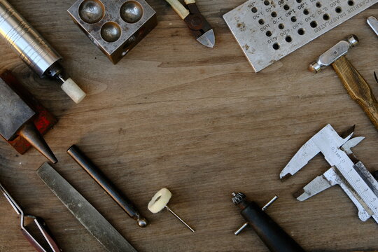 Jeweler's workplace. Top view of jeweler's workbenche with different tools on a wooden table. Goldsmith concept background