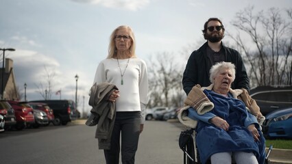Naklejka premium On a bright spring day, a daughter and grandson are taking their elderly mother out for a stroll, enjoying the happiness of family togetherness in the sunshine.