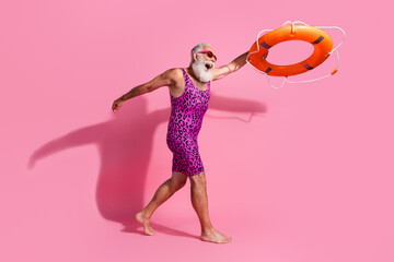 Photo of excited aged man rescuer throw life buoy wear swim suit isolated pink color background