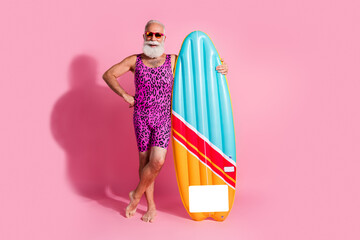Photo of optimistic man pensioner wear swimwear summer vacation resort surfing isolated on pink color background