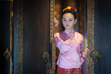 Obraz premium Pretty Asian women in ancient traditional Thai dress. Beautiful Thai dresses in Lanna style make merit according to tradition. Fashion portraits at the Chedi Luang temple in Chiang Mai, Thailand.