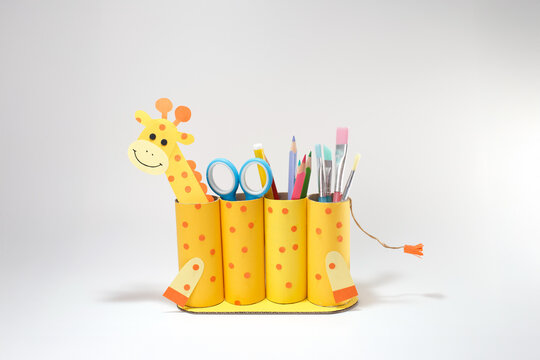 DIY giraffe pencil holder made from toilet paper rolls and color paper, creative kids craft project for school, education blogs, teacher materials, and classroom decoration ideas,