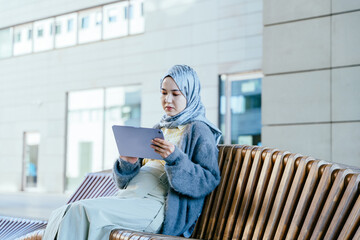Modern Muslim Businesswoman Using Tablet in Outdoor Workspace