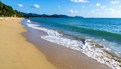 Fototapeta premium Serene Beach Scene with Gentle Waves and Clear Blue Sky