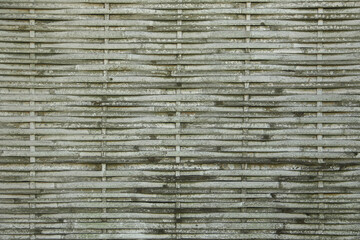 Close-up of a weathered bamboo wall texture, showing natural aging and horizontal pattern – ideal for backgrounds, design elements, and rustic themes.