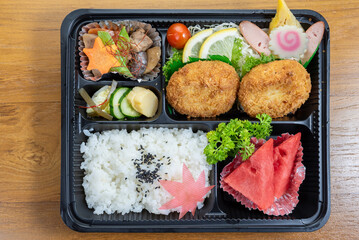 A tray of food with rice, meat, and vegetables