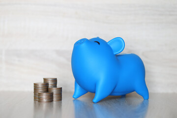 Piggy bank and stack of coins money on wooden background, Save money for prepare in future and pension retirement concept