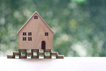Mortgage,Model house and stack of coins money on natural green background,Business investment and real estate concept
