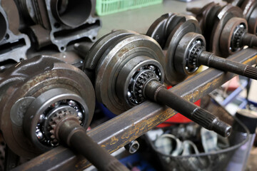 Selective focus of many car crankshafts, motorcycles, used spare parts, closeup of car crankshafts, motorcycles, used spare parts, and spare parts in a car repair shop.