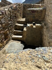 Ancient Inca ruins and stone fortifications at Ollantaytambo, Peru, showcasing impressive pre-Columbian architecture set against the dramatic Andes Mountains. A historic archaeological site rich in cu