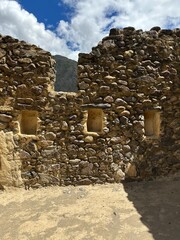 Ancient Inca ruins and stone fortifications at Ollantaytambo, Peru, showcasing impressive pre-Columbian architecture set against the dramatic Andes Mountains. A historic archaeological site rich in cu