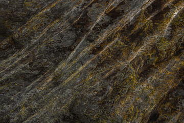 A rocky formation of stone with yellow-orange veins