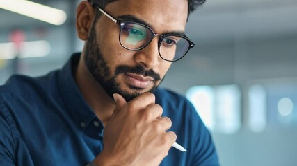 Indian man nods in appreciation of what he watches on the tablet and gently smiles in approval