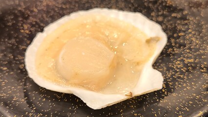 Scallops on a black plate. Seafood restaurant.
