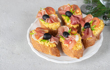 Bruschetta with jamon, egg and cherry tomatoes on white plate