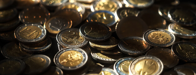 Many Euro coins forming a big pile of european currency under dramatic light