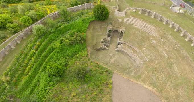 Aerial closeup of the Roman Amphitheatre in the archaeological site of Cuma in the province of Naples, Campania, Italy. It is an amphitheatre built by the ancient Romans in the old town of Cumae.