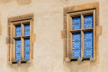 Obraz premium Vintage building with blue stained glass windows in stone frames