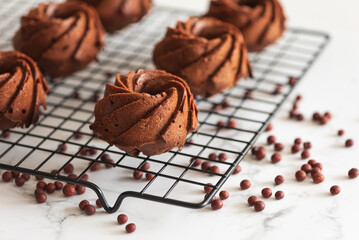 Mini chocolate bundt cakes on a cooling rack. Soft focus