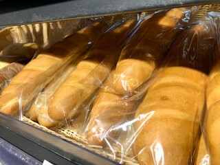 fresh french baguettes on a shelf in a store