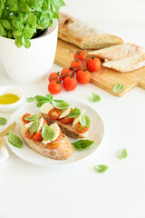 Fresh bruschetta with mozzarella, cherry tomatoes, and basil.