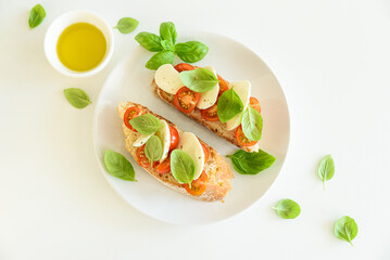 Fresh bruschetta with mozzarella, cherry tomatoes, and basil.
