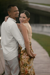 Obraz premium Romantic close-up of an interracial couple in love. Asian man with dark skin and European brunette woman in elegant dress. Love and unity, together forever concept.