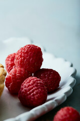Chocolate tart with fresh raspberries on white scalloped plate