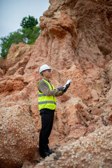 A geologist reviews details of a plan on a clipboard to plan their exploration