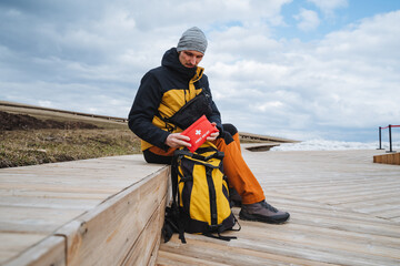 An explorer is preparing for an outdoor journey into the wilderness, equipped with a sturdy backpack filled with all the essential gear for the exciting adventure