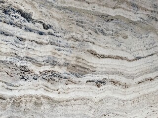 Marble Tile texture closeup as an abstract background. Natural Honed stone slab. Details of matte ceramic wall or floor. Gray surface with satin finish and a pattern of random irregular white spots