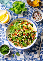 Tabbouleh salad in a bowl. Blue background. Close up. Top view.