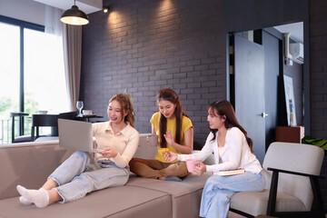 Asian Women Friends Shopping Online Using Laptop and Credit Card At Home Concept of Friendship Lifestyle Technology and E Commerce Relaxing Together