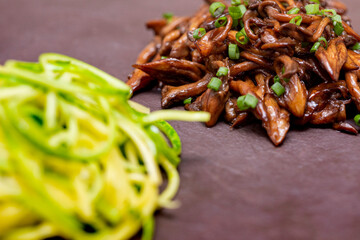 Zucchini spaghetti with shimeji on black stone plate