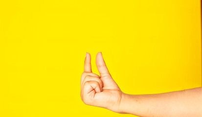  A human hand captured in a holding gesture, isolated against a bright, uniform background. This...