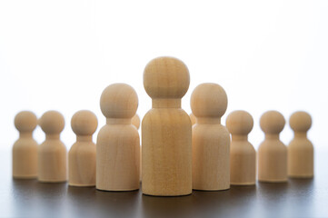 Conceptual representation, with wooden pawns, of a man alone in command, and followers who follow him. Concepts of hierarchy, command and team, superior and subordinate.