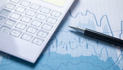 Pen and calculator on a financial graphs. Business