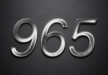 Chrome metal 3D number design of 965 on grey background.