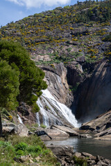 Ézaro Waterfall in Dumbría, Galicia, Spain. Where the Xallas river meets the sea, a rare waterfall flowing directly into the ocean. Stunning natural coastal scenery.