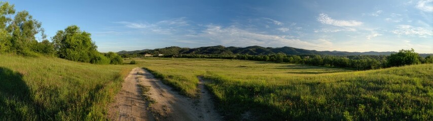 Fototapeta premium Panoramic Rural Landscape Countryside Path and Distant Buildings